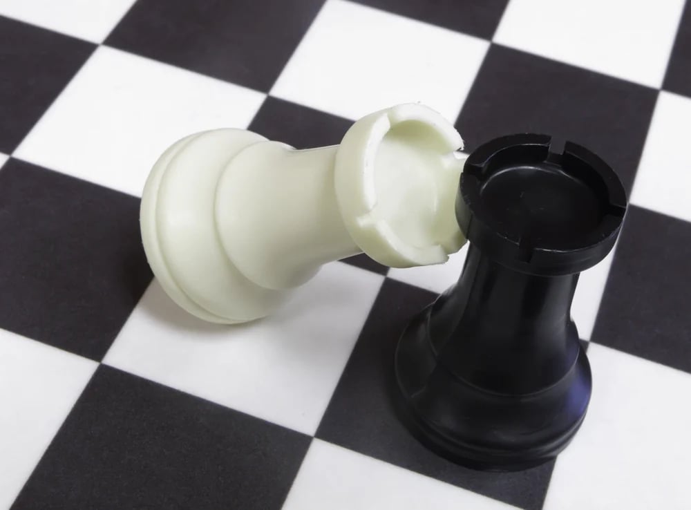 White rook topples against black rook on chessboard-1