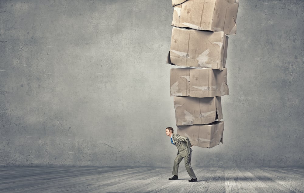 Young businessman in suit carrying big stack of carton boxes-1
